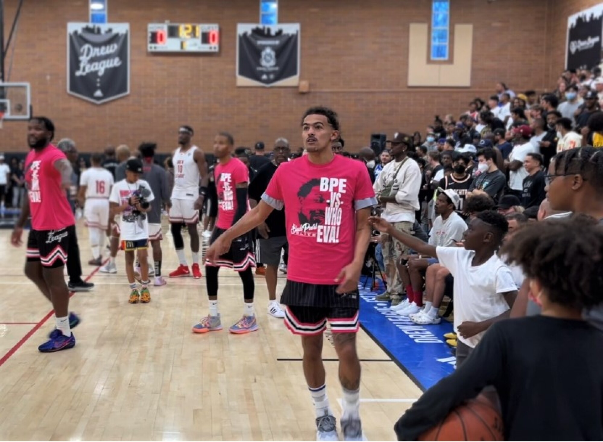 Hawks defenseman Trae Young warms up with Black Pearl Elite teammates ahead of a Drew League game on Saturday.