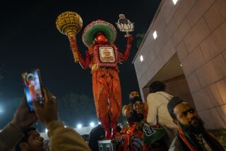Un seguidor del Partido Bharatiya Janata (BJP) vestido como el dios mono hindú Hanuman, observa al primer ministro indio Narendra Modi hablar durante una ceremonia de celebración electoral en la sede del partido en Nueva Delhi, India, el jueves 8 de diciembre de 2022. (Foto AP/Altaf Qadri)