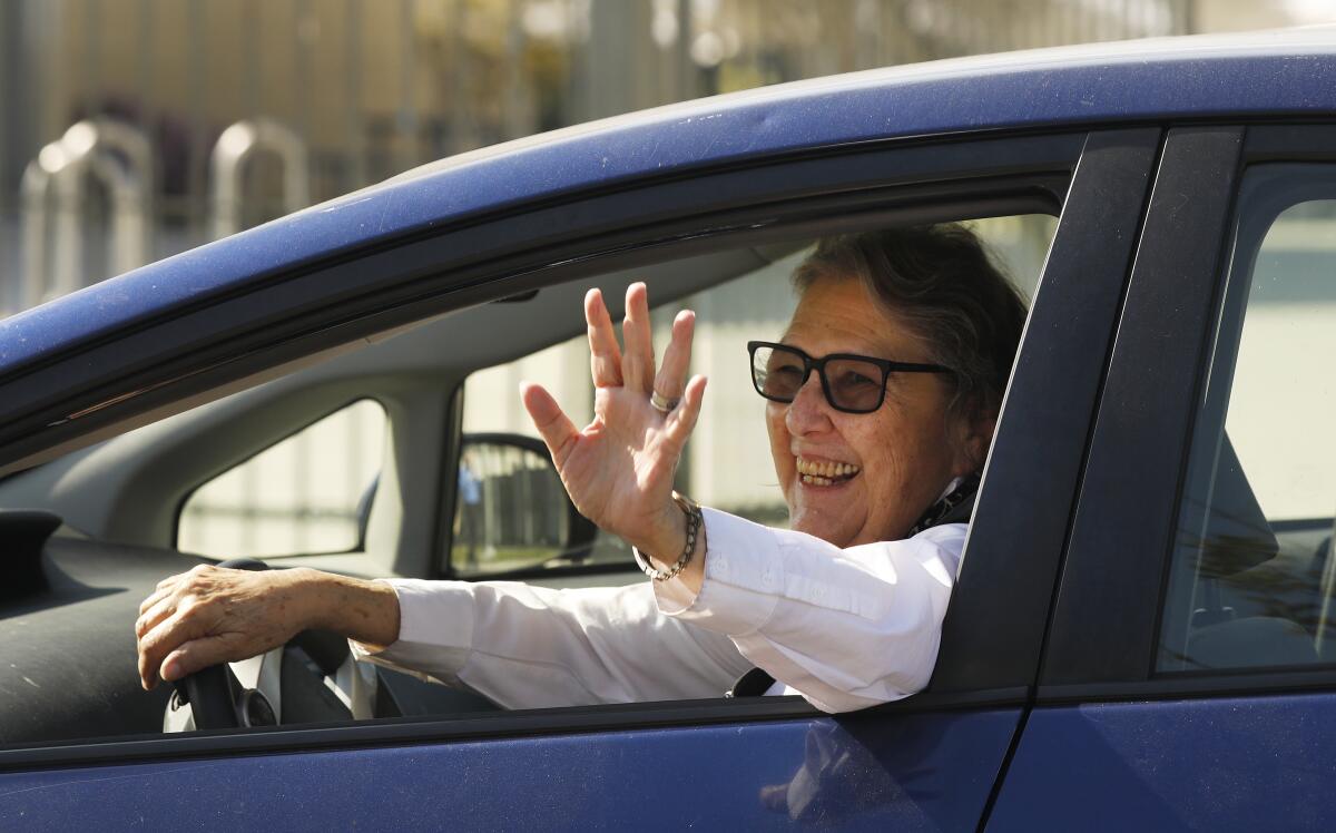  Jackie Goldberg waves from the window of a blue car. 