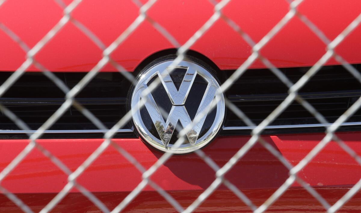 A Volkswagen diesel sits behind a security fence on a storage lot near a VW dealership Wednesday, Sept. 23, 2015, in Salt Lake City.