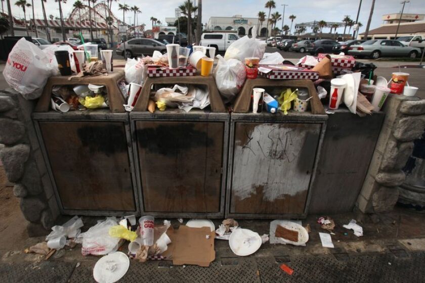Trash, including plenty of plastic bags, overflows from bins at Belmont Park in Mission Beach.