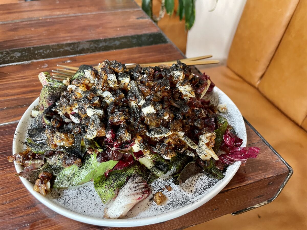 A plate piled with Romaine lettuce and dusted with onion ash.