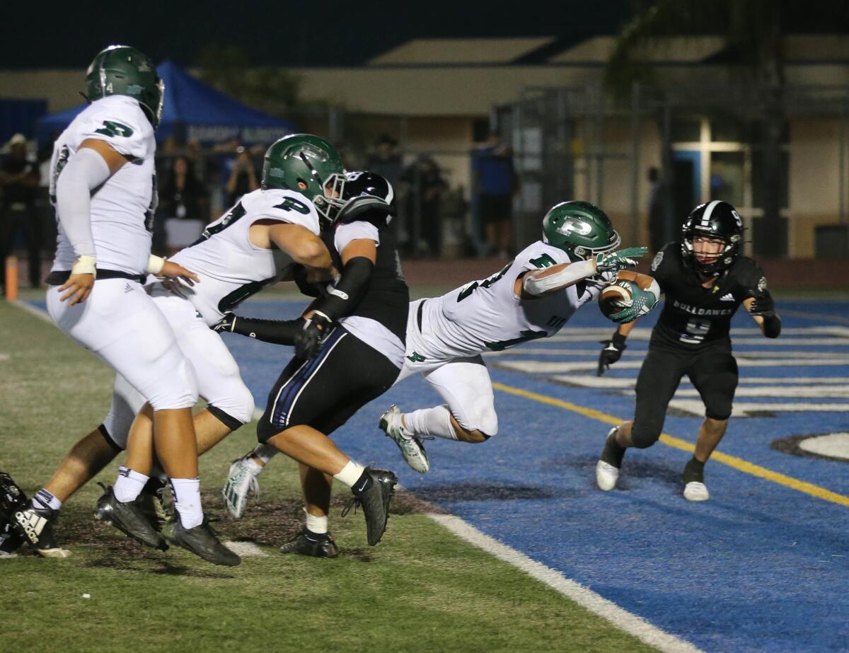 Poway High's Jake Tsay dives in for the tying score from 5 yards out in overtime in Friday night's game against Ramona.