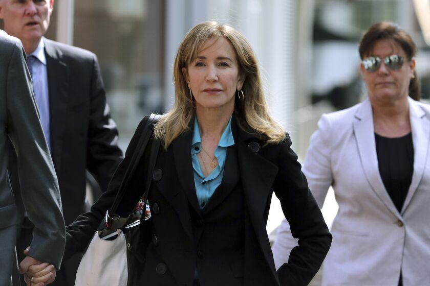 FILE - This April 3, 2019 file photo shows actress Felicity Huffman arriving at federal court in Boston to face charges in a nationwide college admissions bribery scandal. Huffman is facing a prison sentence after agreeing to plead guilty to one count of conspiracy and fraud for paying a consultant $15,000 disguised as a charitable donation to boost her daughter's SAT score.