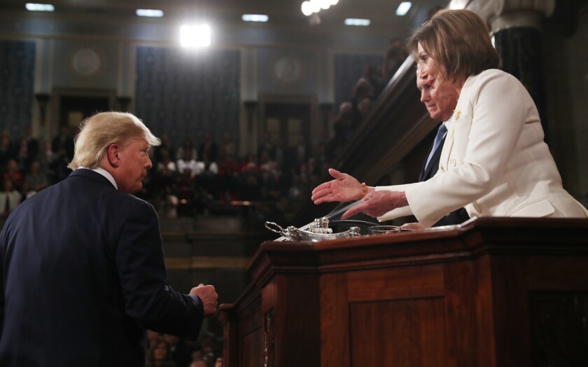 President Donald Trump arrives to deliver his State of the Union address to a joint session of Congress in the House Chamber on Capitol Hill in Washington, Tuesday, Feb. 4, 2020, as Speaker Nancy Pelosi reaches to shake his hand, an overture Trump ignored.
