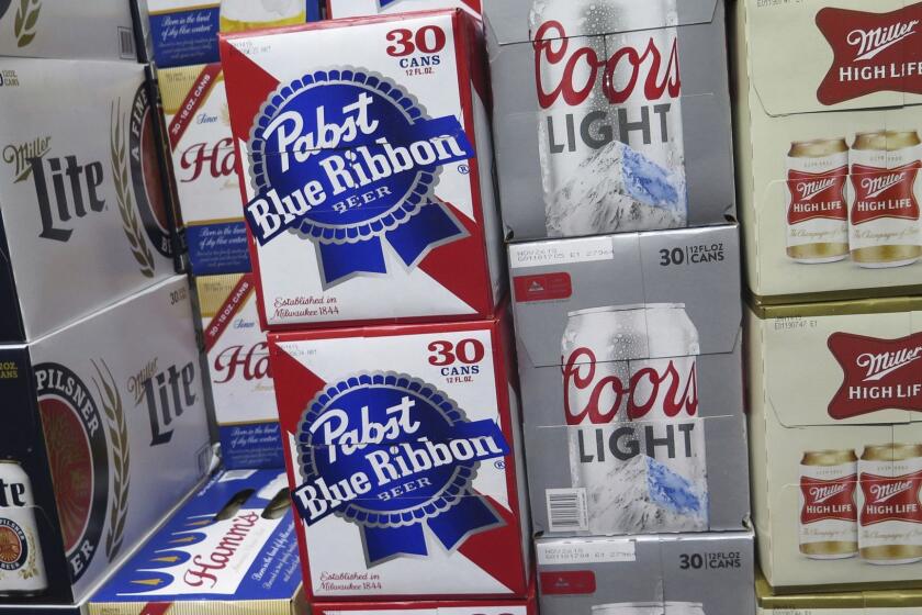 In this photo taken on Thursday, Nov. 8, 2018, cases of Pabst Blue Ribbon and Coors Light are stacked next to each other in a Milwaukee liquor store. Pabst Brewing Company and MillerCoors are heading to trial starting Monday, Nov. 12, to settle a contract dispute in which Pabst accuses the brewing giant of trying to undermine its competitor by breaking a contract to make their products. (AP Photo/Ivan Moreno)