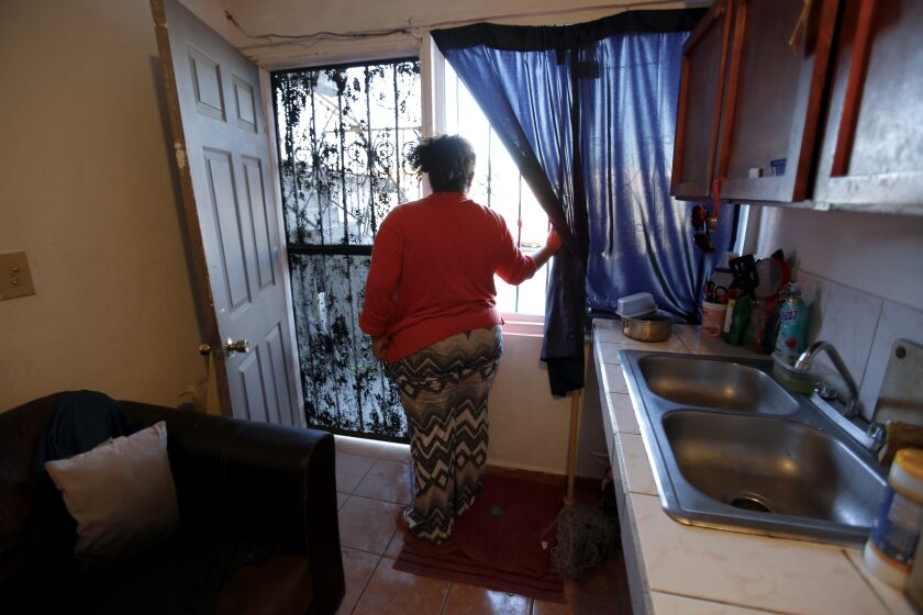 Bárbara, a Nicaraguan citizen, looks out her apartment window in Tijuana. Bárbara was selected for Migrant Protection Protocols (MPP) known widely as "Remain in Mexico" and is living in Tijuana waiting for her asylum case to be heard in U.S. immigration court. She was attacked by paramilitary men working with the government to silence protesters in the spring of 2018 in Managua, Nicaragua.