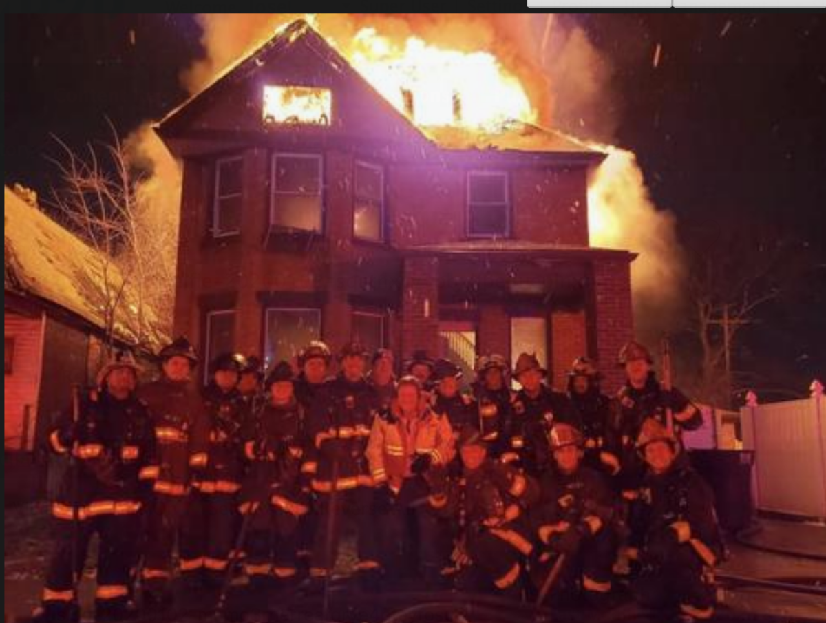 Los bomberos de Detroit posan frente a un edificio en llamas en una foto que luego fue tomada por la Página de Incidentes de Incendios de Detroit en Facebook. Aunque no está claro cuándo se tomó, el título inicial era "Los equipos se toman un momento para hacerse una foto de Año Nuevo".