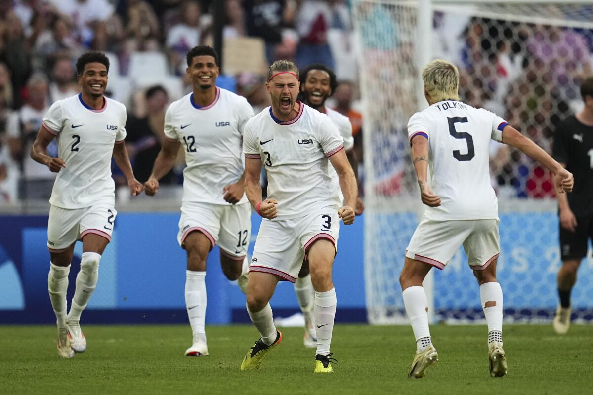 American Walker Zimmerman, center, celebrates after scoring during a Group A soccer match against New Zealand.