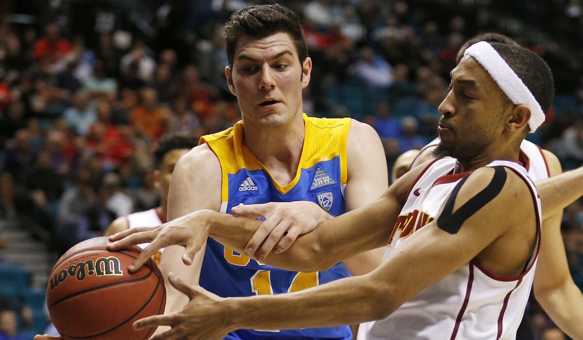 UCLA forward Gyorgy Goloman, left, and USC guard Jordan McLaughlin battle for the ball during the second half in the first round of the Pac-12 men's tournament on Wednesday in Las Vegas.