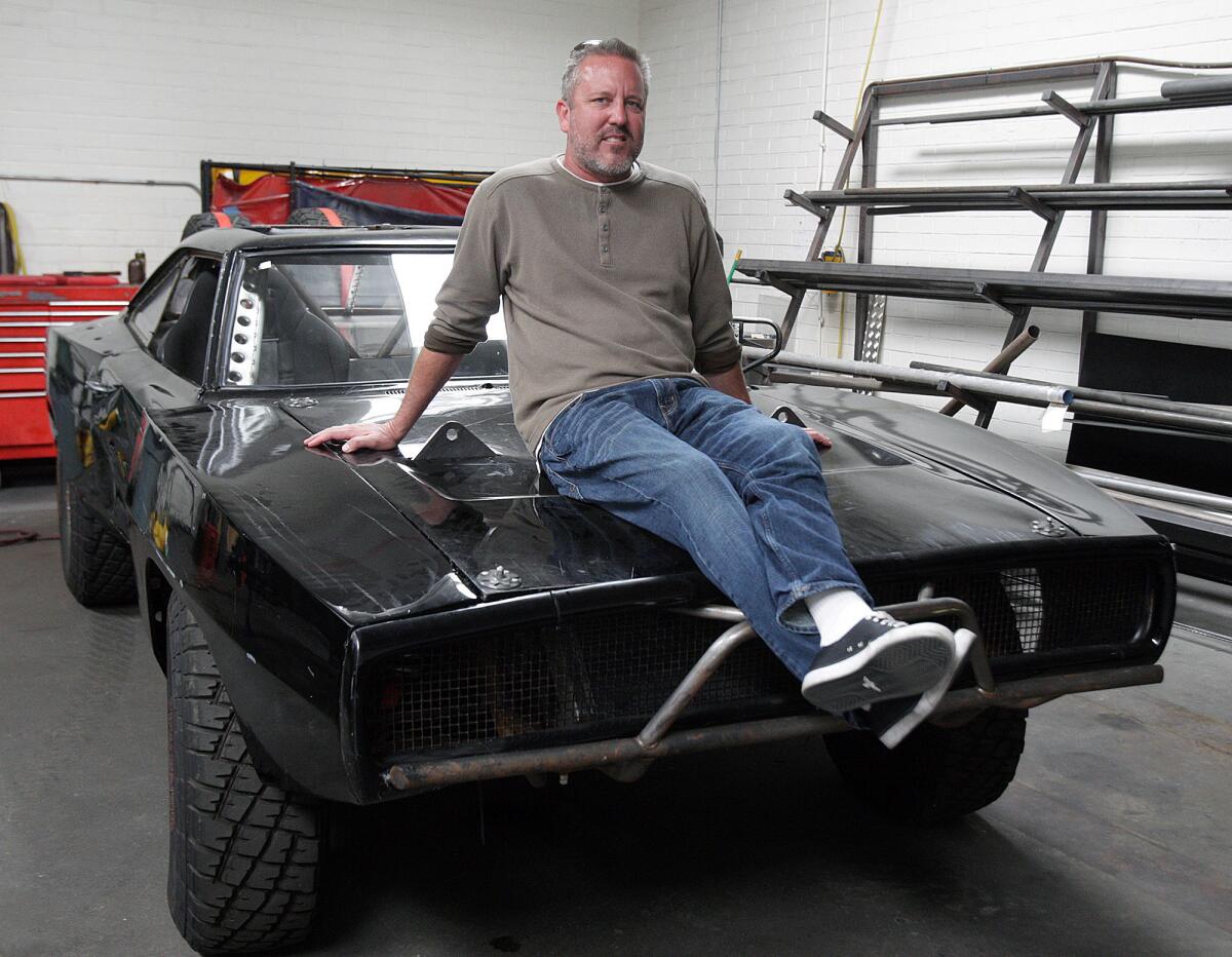 Picture car coordinator Dennis McCarthy, a Burbank native, sits atop the modified Dodge Charger that was dropped out of an airplane in the movie "Furious 7" at Vehicle Effects, Inc. in Sun Valley on Friday, April 10, 2015. McCarthy's company envisioned and acquired the vehicles used, and how they were used, in several "Fast and Furious" movies.