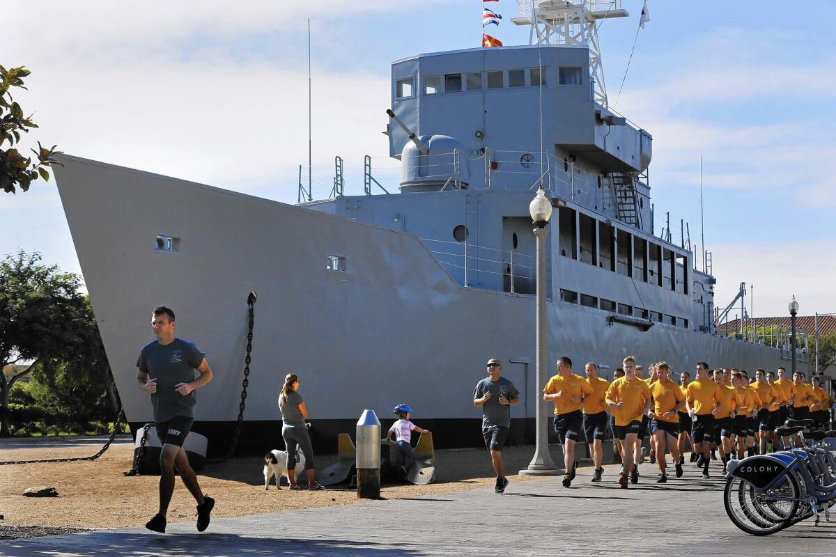 Navy personnel jog past the Recruit, nicknamed the "Neversail," in San Diego. It is the only commissioned ship in the Navy that never touched water.
