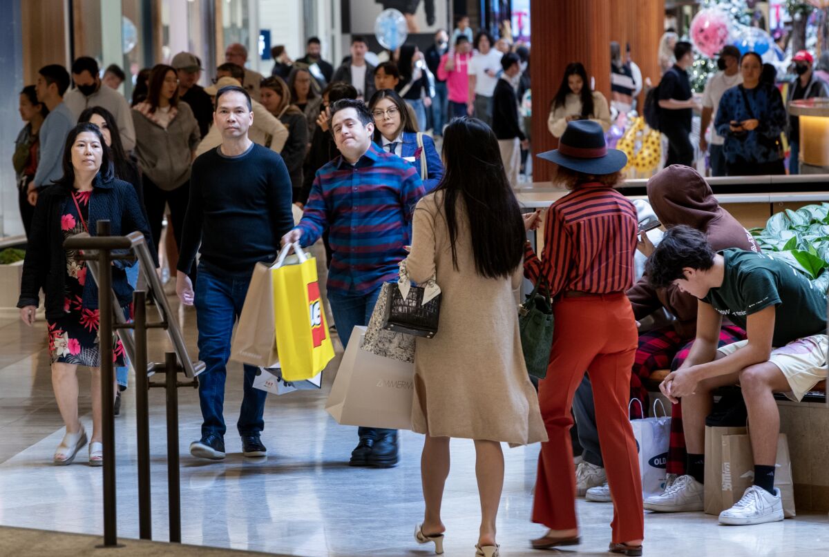 Shoppers maneuver through the crowd while searching for Black Friday deals at South Coast Plaza.