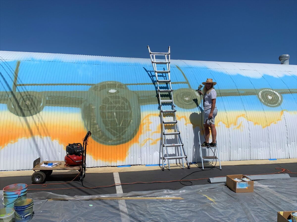 Nancy Hadley works on a mural of a Consolidated B-24 Liberator bomber at the former site of the Santa Ana Army Air Base.
