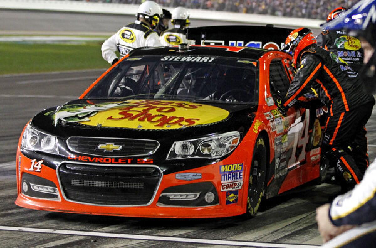 Crew members work on NASCAR driver Tony Stewart's car during the Daytona 500 on Sunday, when he had mechanical problems that forced him to the garage for repairs.
