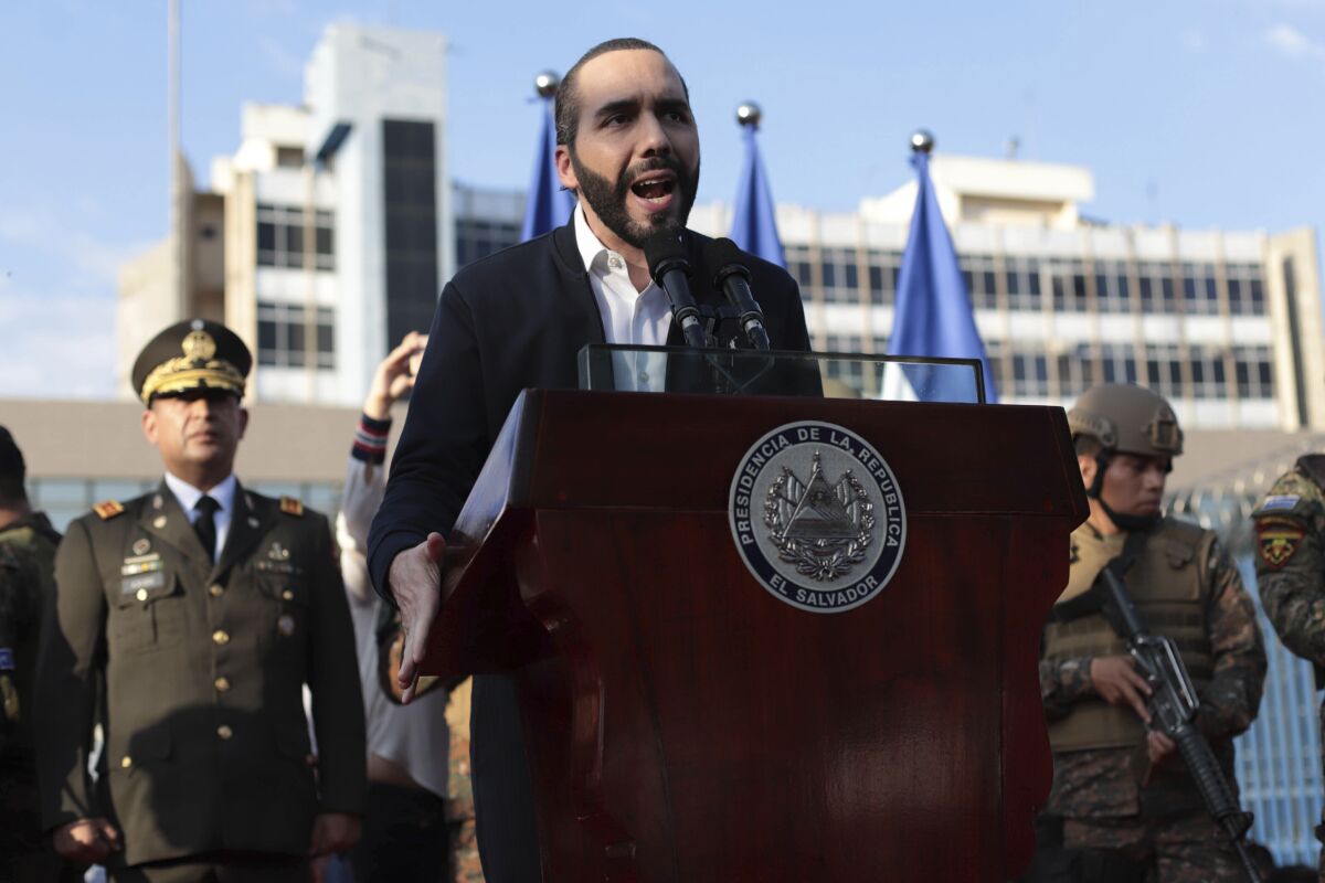 FILE - In this Feb. 9, 2020 file photo, El Salvador's President Nayib Bukele, accompanied by members of the armed forces, speaks to supporters outside Congress in San Salvador, El Salvador. Bukele has imposed some of the region's toughest measures against the new coronavirus and a growing number of human rights advocates at home and abroad complain the 38-year-old leader has used the emergency to seize near-dictatorial powers. (AP Photo/Salvador Melendez, File)
