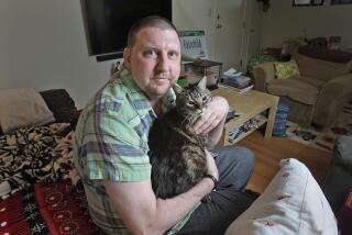 Matt Fairchild with his cat Jacques in his living room in Burbank in March 2016. Fairchild has melanoma, a skin cancer that has resulted in tumors in his brain. (Tim Berger / Staff Photographer)