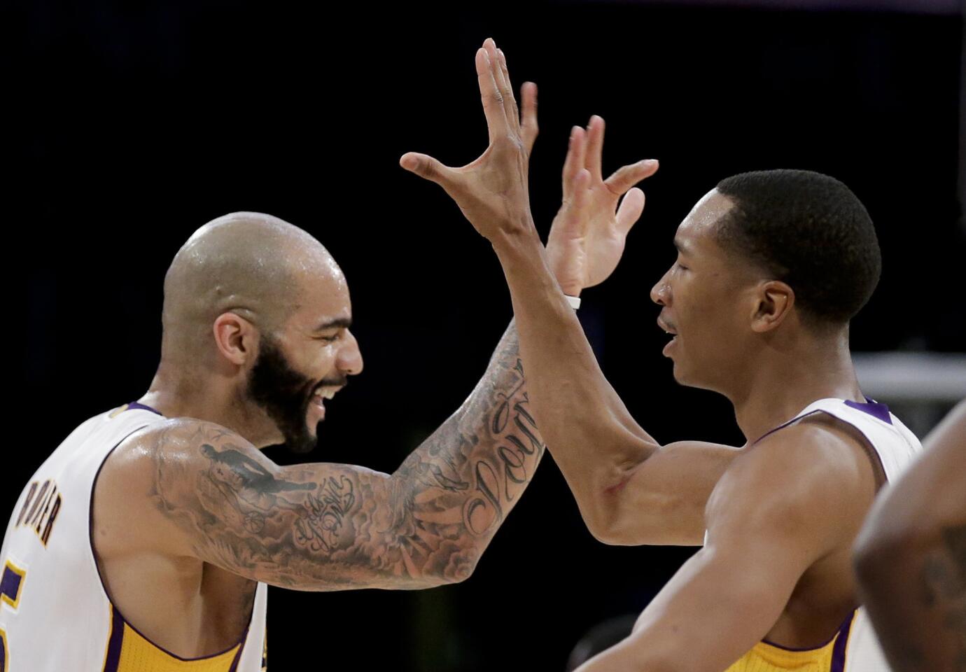 Forwards Carlos Boozer, left, and Wesley Johnson celebrate after the Lakers scored a basket against the Celtics in overtime on Sunday night at Staples Center.