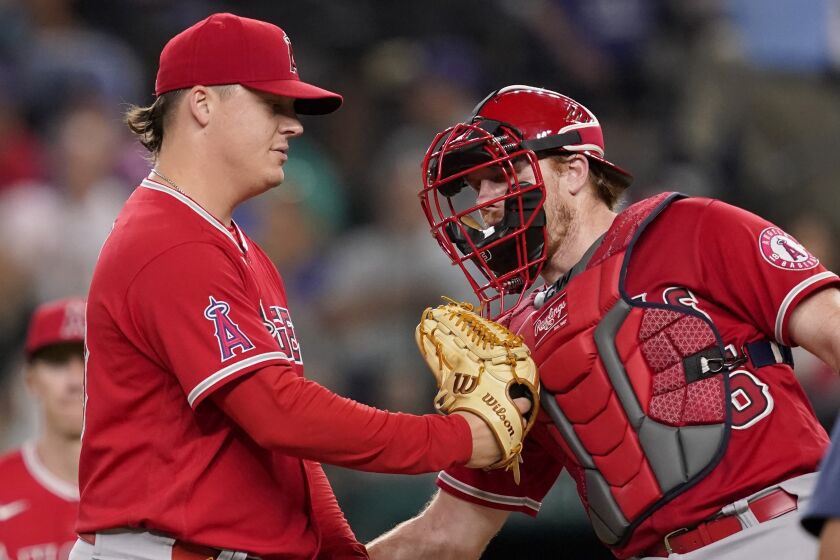 Los Angeles Angels' Aaron Loup and Chad Wallach talk on the mound before Loup turned the ball over.