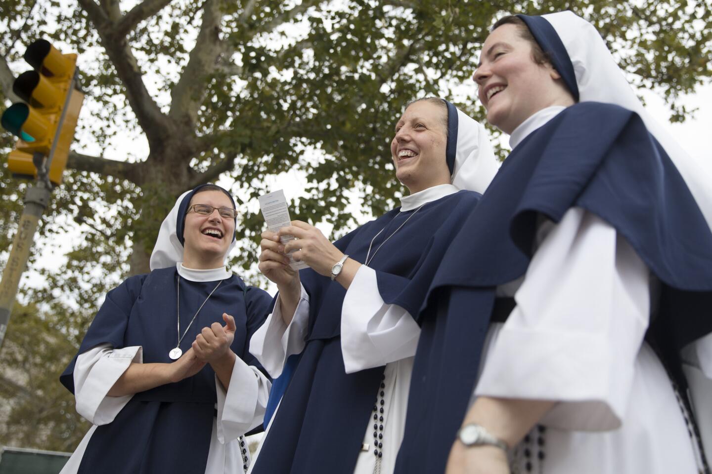 Sister Beatrice, center, of The Sisters of Life, of New York City, smiles as she holds her ticket by a checkpoint as they arrive for a Mass to be celebrated by Pope Francis, Sunday, Sept. 27, 2015, in Philadelphia.