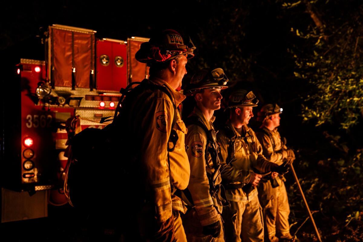 From left, firefighters Gary Mattingly, Tim Zanotelli, Brandon Tolp and Devon Elenburg, all based in San Bernardino, stand ready to swing into action along Highway 29 north of Calistoga on Oct. 12.
