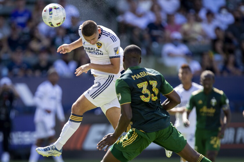 Galaxy forward Dejan Joveljic leaps to head the ball for a goal against Portland Timbers defender Larrys Mabiala.