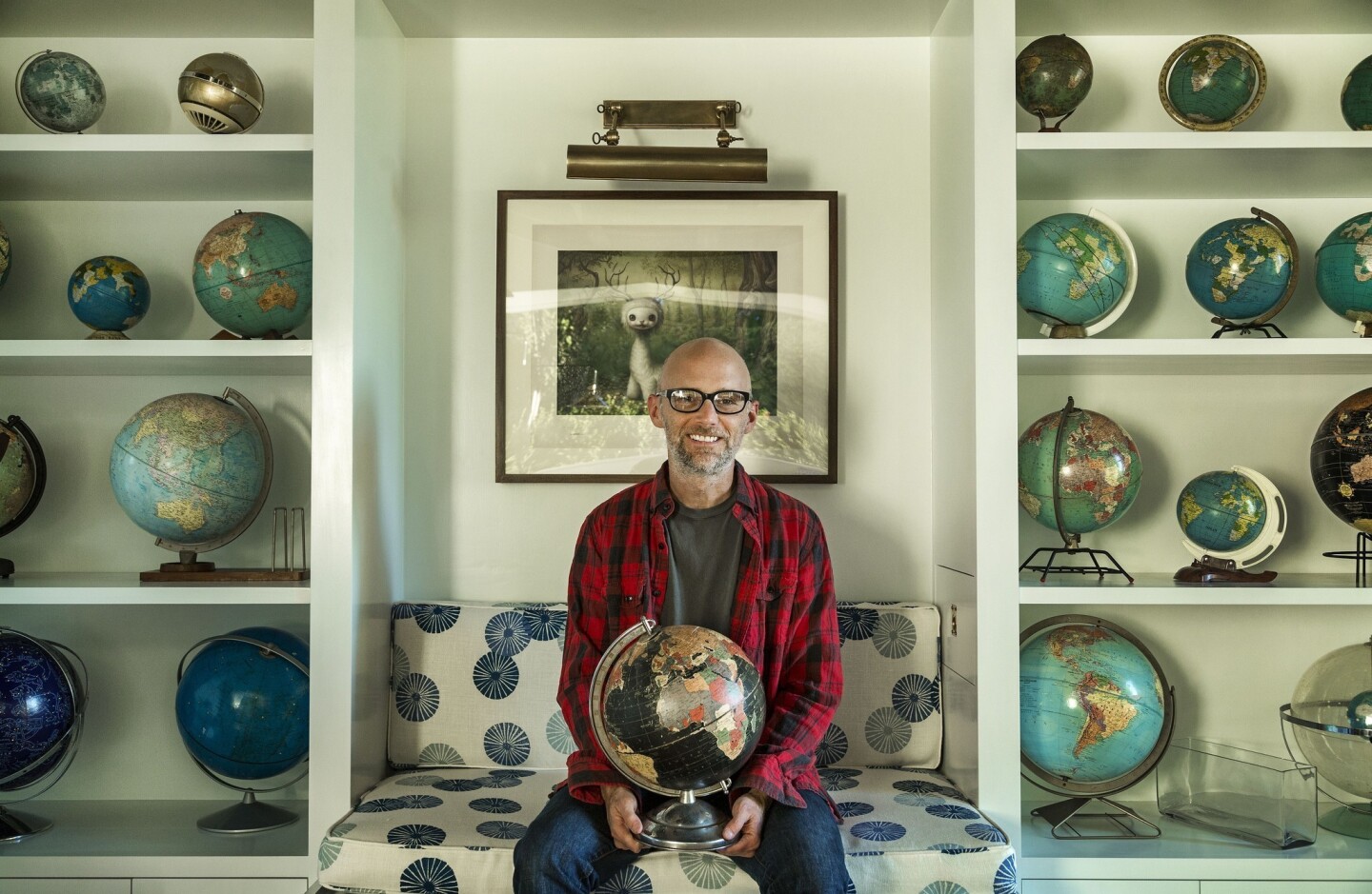 Moby holds his first globe, which he purchased as a child shopping with his mother at a thrift store. He collects vintage globes that show country place names that have disappeared into history, such as Rhodesia and Indochina. "It's an object lesson in impermanence," he says.