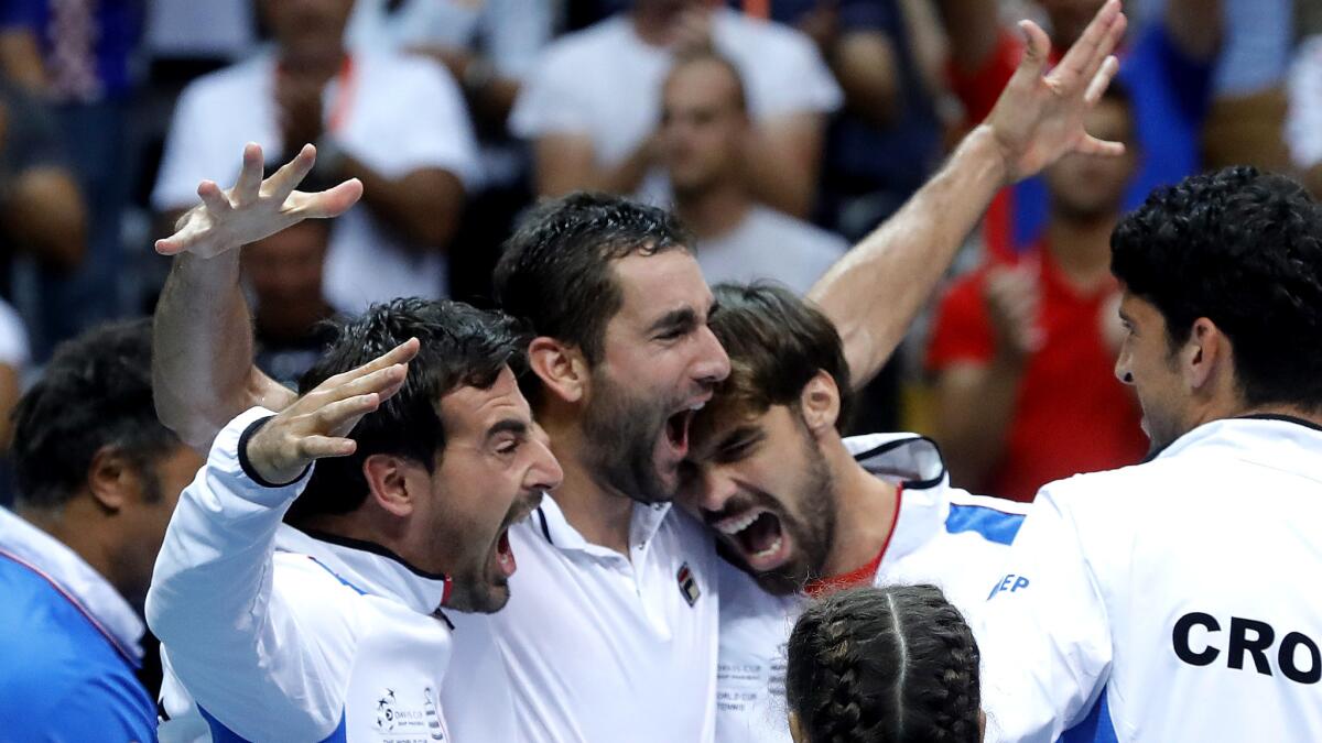 Marin Cilic (arms raised) celebrates Sunday with his Croatian teammates after clinching a spot in the Davis Cup final.