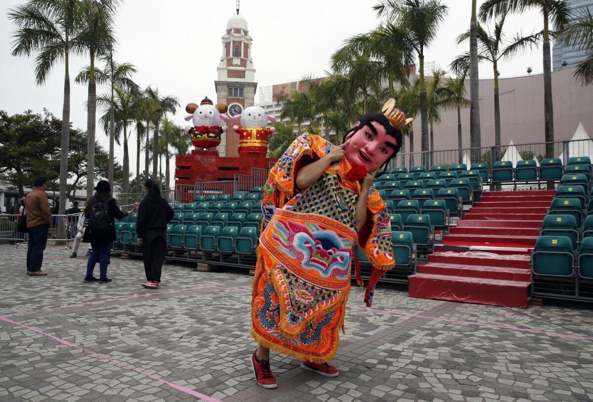 A performer from Taiwan dressed as the "Third Prince" poses for a photograph in front of the sheep decorations during the rehearsal of International Chinese New Year Night Parade in Hong Kong Wednesday.