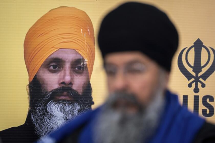 Al fondo se ve la foto de Hardeep Singh Nijjar durante una conferencia de prensa de la comunidad sij sobre el homicidio de su líder en junio de 2023 en Surrey, Columbia Británica, el 3 de mayo de 2024. (Ethan Cairns/The Canadian Press vía AP)