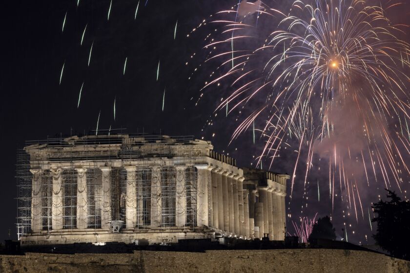 FILE - Fireworks explode over the ancient Parthenon temple at the Acropolis hill during New Year celebrations in Athens, Greece, Sunday, Jan. 1, 2023. Credit ratings agency Fitch has raised Greece’s credit rating to one notch below investment grade. In a report issued Friday, Jan. 27, 2023, Fitch estimates that Greece’s deficit will shrink to 1.8% of its gross domestic product in 2024 from an estimated 3.8% last year. (AP Photo/Yorgos Karahalis, File)