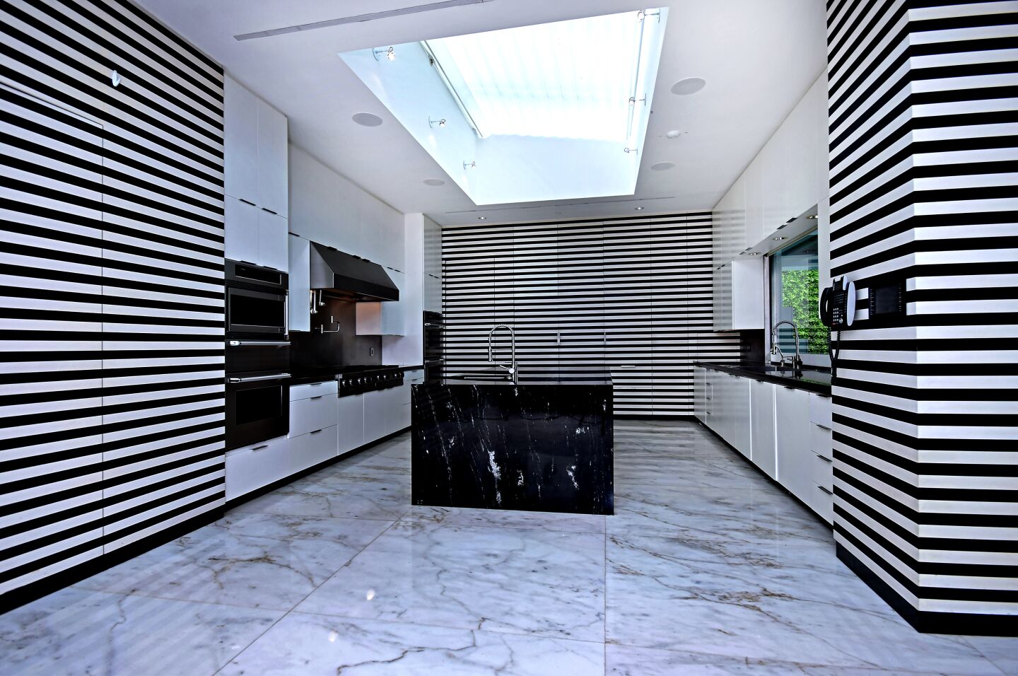 Singer Gwen Stefani sold her contemporary-style compound in the Beverly Hills Post Office area to stand-up comic Sebastian Maniscalco for $21.65 million. The 11,845-square-foot spread, which was once owned by Jennifer Lopez, features bold splashes of color, book-matched marble slabs and a black-and-white striped kitchen. The property sits on about two acres and has a swimming pool, a tennis court and a playground. At the far end of the property is a chicken coop.