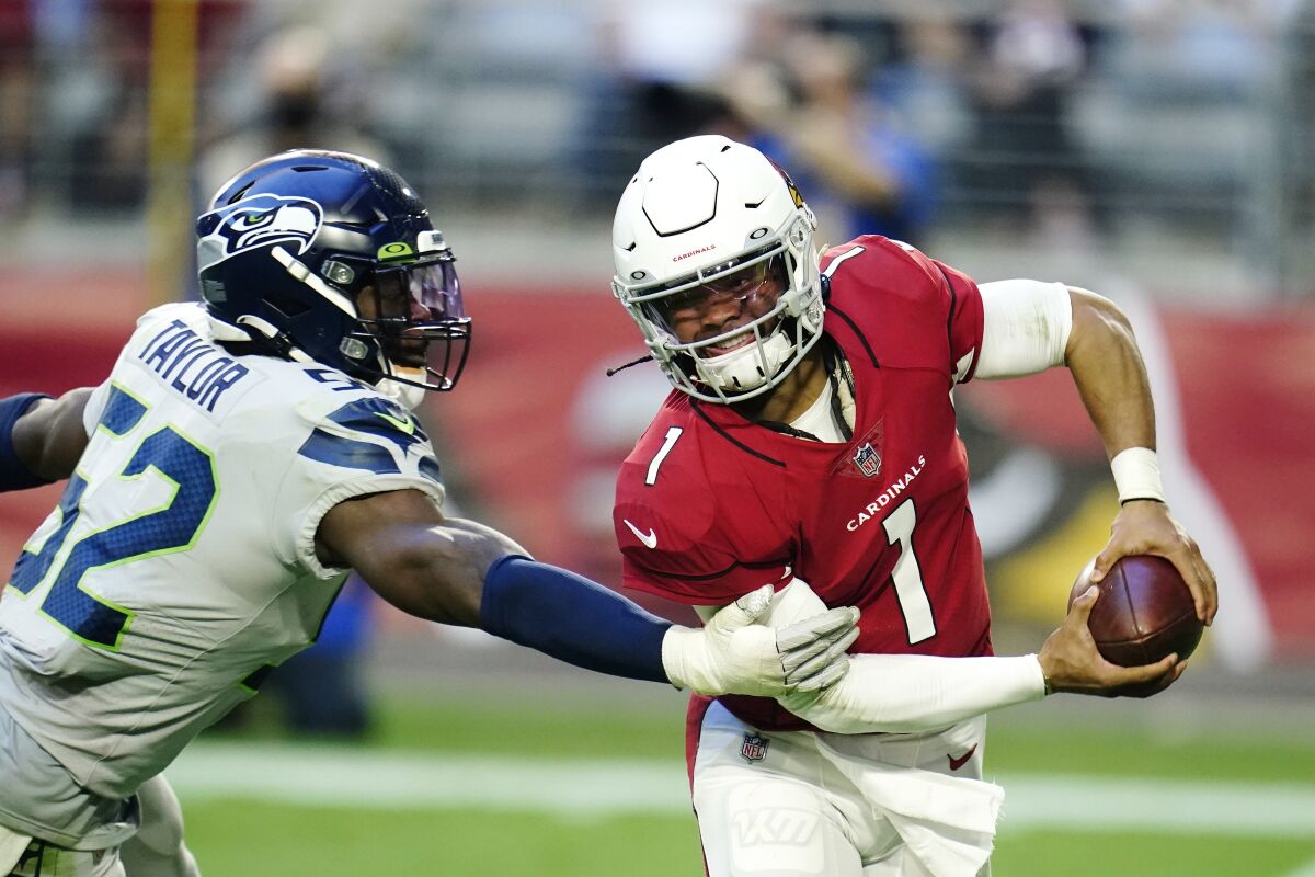 Seattle Seahawks defensive end Darrell Taylor (52) wraps up Arizona Cardinals quarterback Kyler Murray (1) for a sack during the second half of an NFL football game Sunday, Jan. 9, 2022, in Glendale, Ariz. (AP Photo/Darryl Webb)