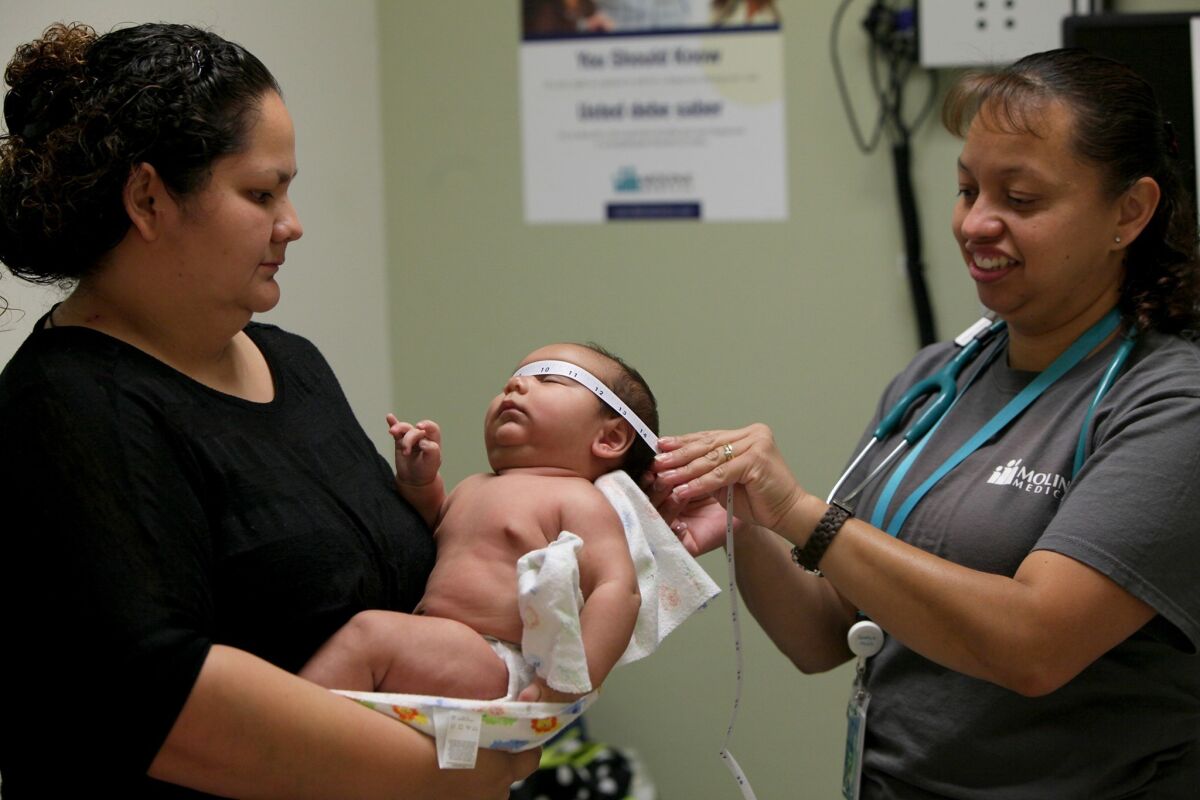 State officials said that more than 59,000 Californians have signed up for health insurance through mid-November. Above, Marisela Garcia, 27, holds her baby boy at a clinic in Fontana last month. Garcia was looking to purchase insurance through the state exchange.