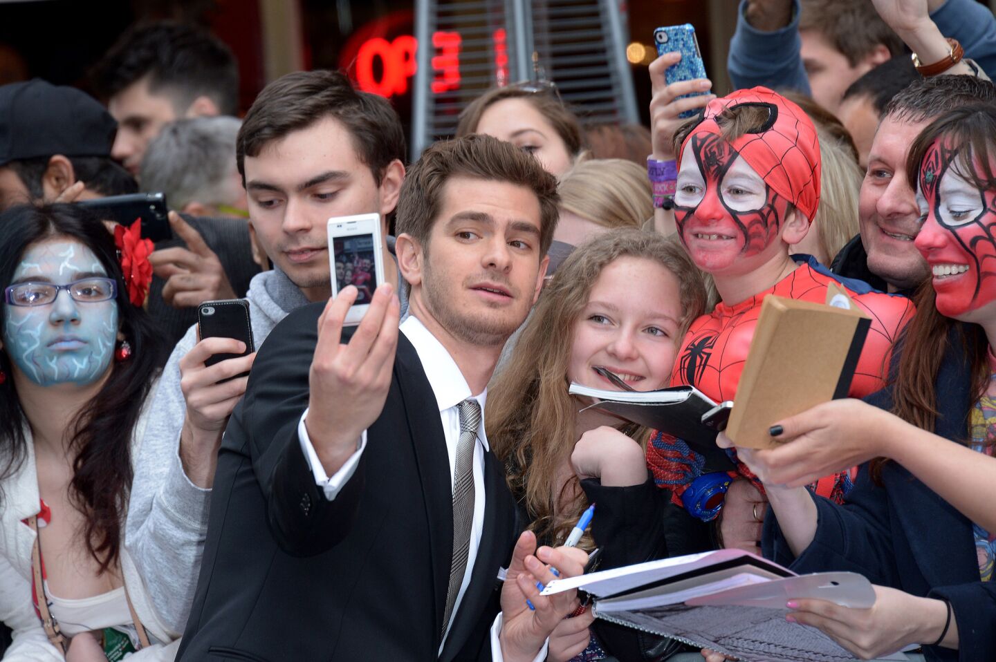 Andrew Garfield takes a selfie with fans as he arrives on the red carpet for the world premiere of "The Amazing Spider-Man 2" in Leicester Square, London, on April 10, 2014.