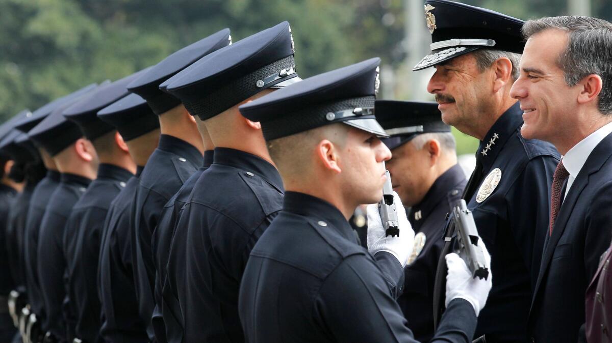 Police Chief Charlie Beck, second from right, and Mayor Eric Garcetti, right. inspect a new group of LAPD officers at a 2015 graduation ceremony. (Brian van der Brug / Los Angeles Times)