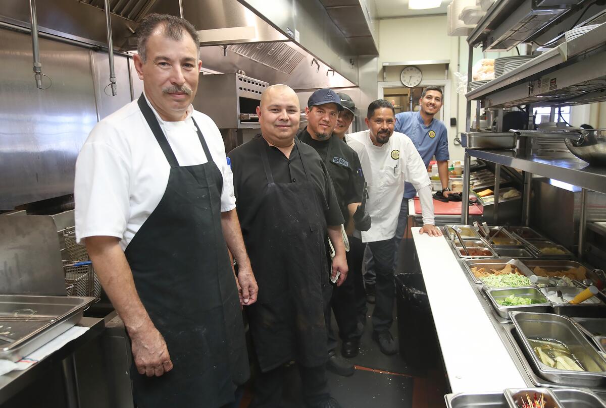 Head chef Ulysses Dominguez, far left, stands with his staff in the kitchen.