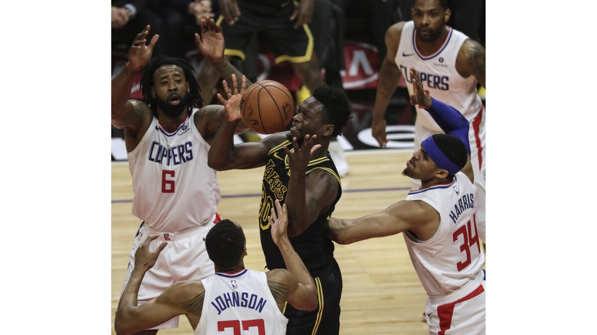 Lakers forward Julius Randle controls an errant pass as Clippers defenders DeAndre Jordan, Tobias Harris and Wesley Johnson defend during first half action.