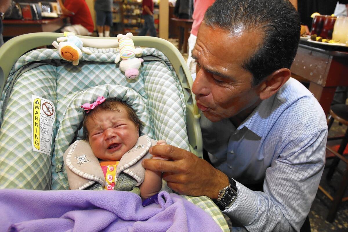 Antonio Villaraigosa greets a baby at Philippe the Original restaurant in Los Angeles in June 2013. The former L.A. mayor is considering running for the U.S. Senate seat being vacated by Barbara Boxer.
