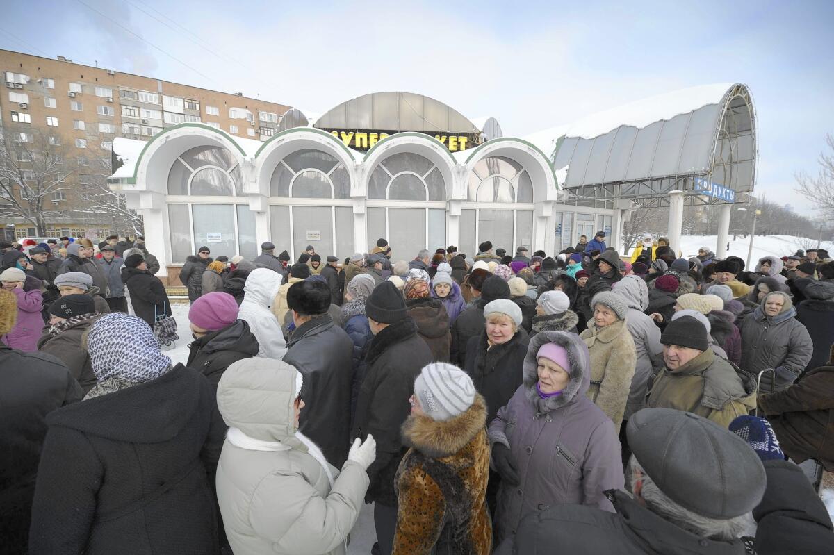People line up at a food distribution center run by an aid group in Donetsk, eastern Ukraine. The war in the east between separatists and government forces is exacting a heavy economic toll.