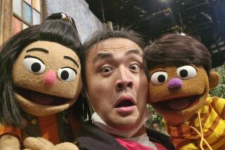 Korean American muppet, Ji-Young with voice actor and puppeteer Yinan Shentu with the new Filipino muppet, TJ.