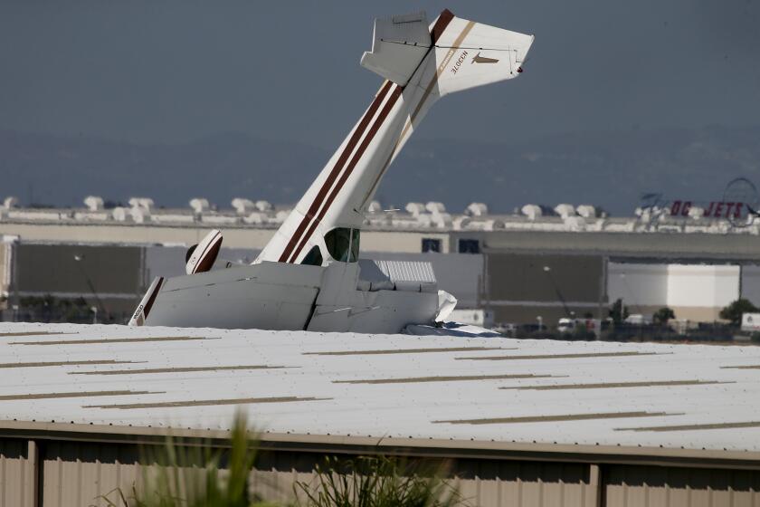 Long Beach, CA - A small plane sits with its tail up after crashing into a building at the Long Beach Airport on Monday, July 10, 2023. July 10: in Long Beach on Monday, July 10, 2023 in Long Beach, CA. (Luis Sinco / Los Angeles Times)