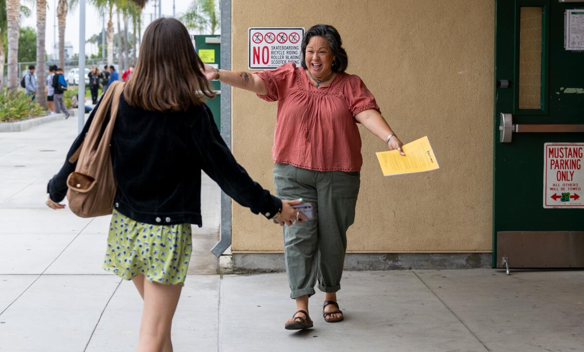 A teacher and former student greet on the first day of classes at Costa Mesa Middle and High School.