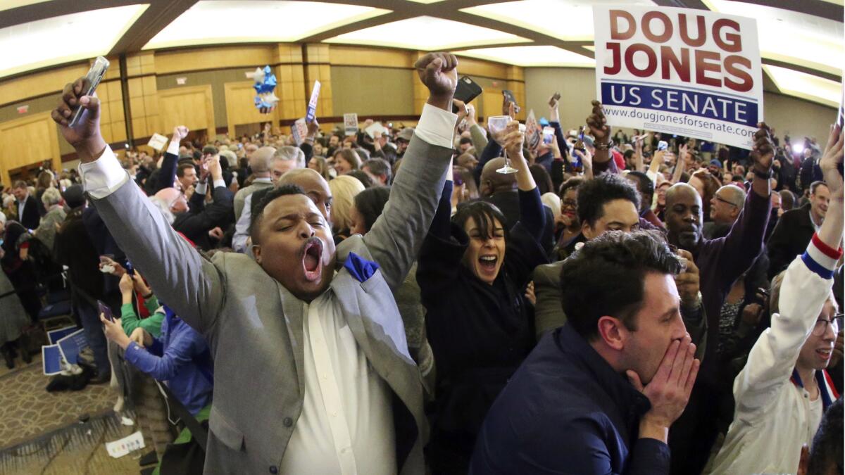 Supporters of Democrat Doug Jones begin to celebrate at an election-night watch party in Birmingham, Ala.
