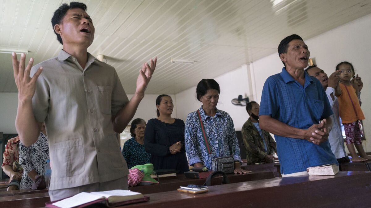 Norng Chhay, right, in blue shirt, participates in a Sunday service at the Pailin's B.P. Presbyterian Church. Norng was a Khmer Rouge soldier for almost 20 years. He converted to Christianity in 2000.