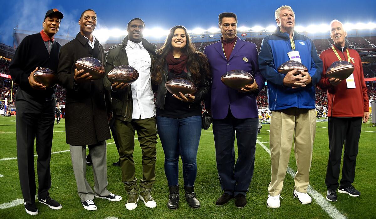 Members of the Pac-12 All Centrury Team, from left to right, Ronnie Lott, Marcus Allen, Reggie Bush, Sydney Seau representing her father Junior Seau, Joey Browner, Ron Yart, Jim McKay, on behalf of his father John McKay, stand together prior to the Pac-12 Championship game on Saturday.