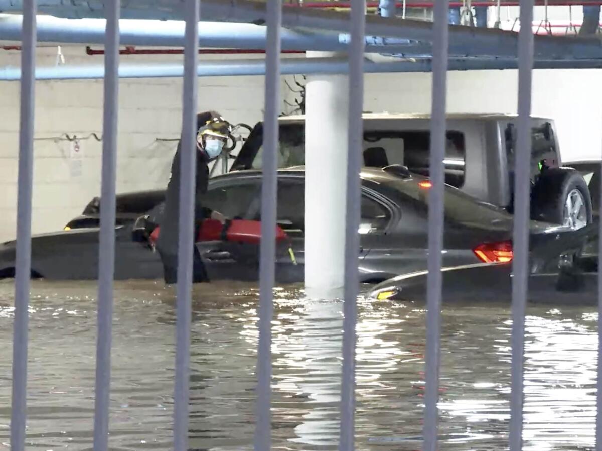 An L.A. County lifeguard checks vehicles in an underground parking lot.