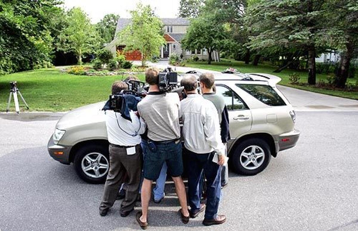 MEDIA FRENZY: Reporters interview a neighbor of John Ramsey, JonBenets father, in front of Ramseys home in Charlevoix, Mich. Ramsey has said he does not think he knows Karr