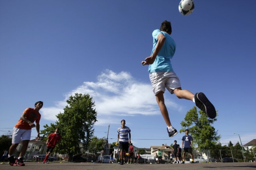 A teenage soccer player jumps up to head the ball in Oakland. A new study finds that the most frequent cause of concussions among high school soccer players is collisions with other athletes, not heading.