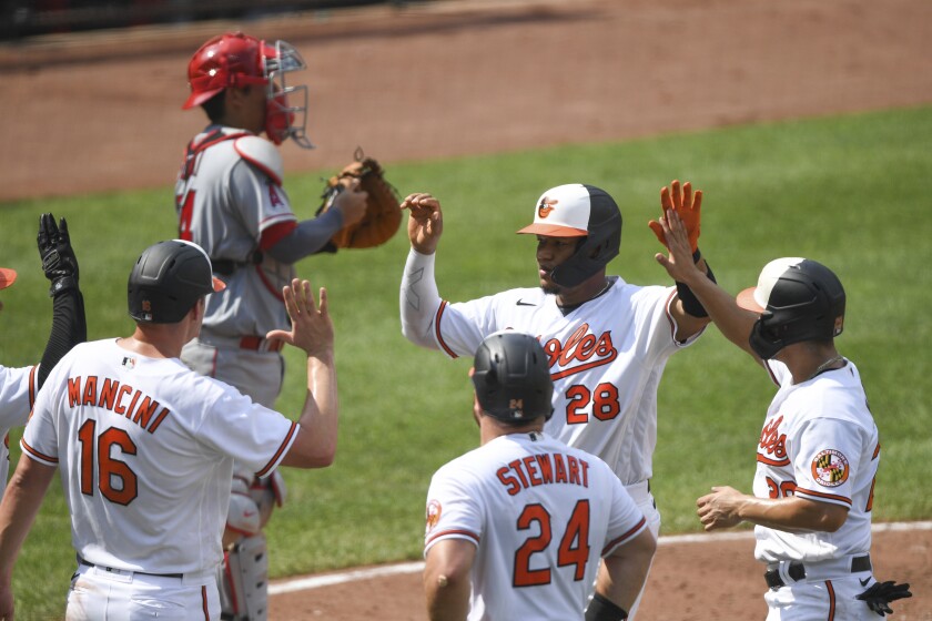 Baltimore's Pedro Severino is greeted by teammates at home plate after hitting a fifth-inning grand slam.